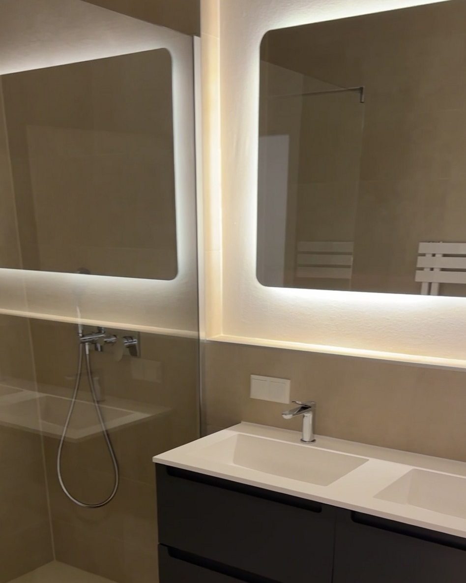 Saniertes Bad mit Walk-in-Dusche, beleuchtetem Spiegel und Waschtisch